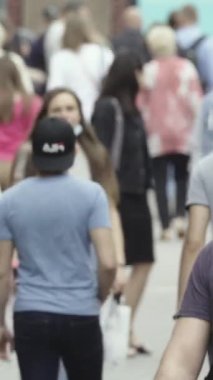 Vertical video of pedestrians walking along a city street