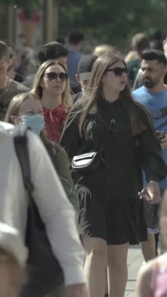 Vertical video of pedestrians walking along a city street — Video