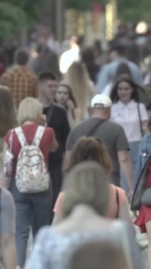 Vertical video of pedestrians walking along a city street