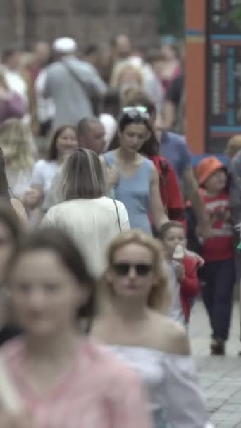 Vertical video of pedestrians walking along a city street — ストック動画