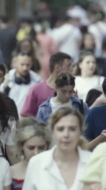 Vertical video of pedestrians walking along a city street