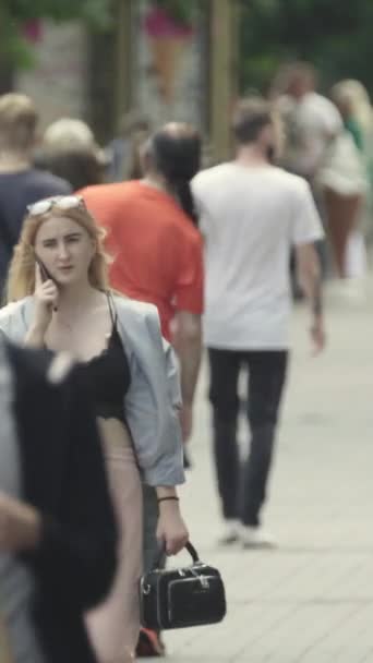 Vertical video of pedestrians walking along a city street — Vídeos de Stock