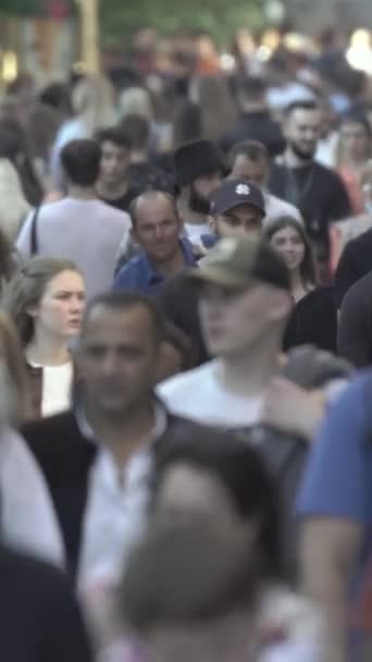 Vertical video of pedestrians walking along a city street — Stok video