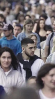 Vertical video of pedestrians walking along a city street