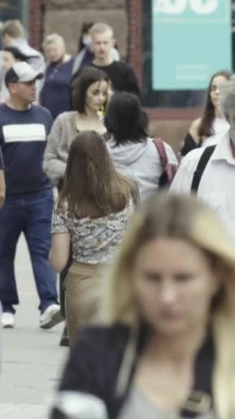 Vertical video of pedestrians walking along a city street — Stok video