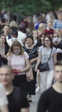 Vertical video of pedestrians walking along a city street