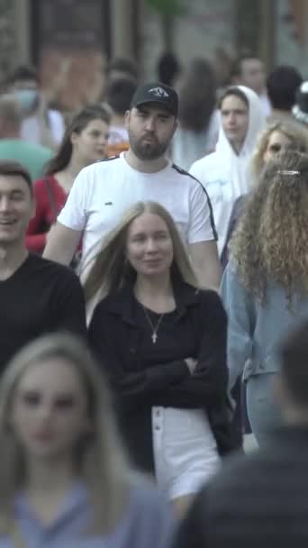 Vertical video of pedestrians walking along a city street — стоковое видео