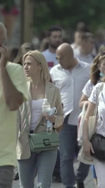 Vertical video of pedestrians walking along a city street — Stok video