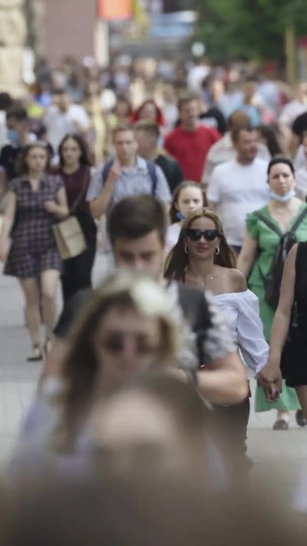 Κάθετη βίντεο από πολλούς ανθρώπους που περπατούν σε ένα πλήθος κατά μήκος ενός δρόμου της πόλης — Αρχείο Βίντεο