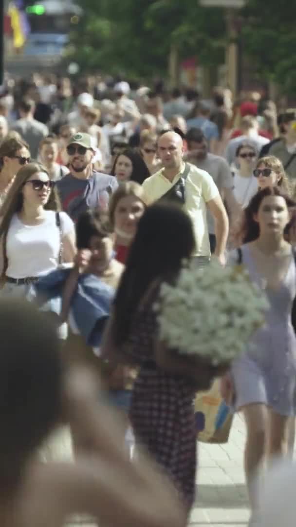 Vidéo verticale de nombreuses personnes marchant dans une foule le long d'une rue de la ville — Video