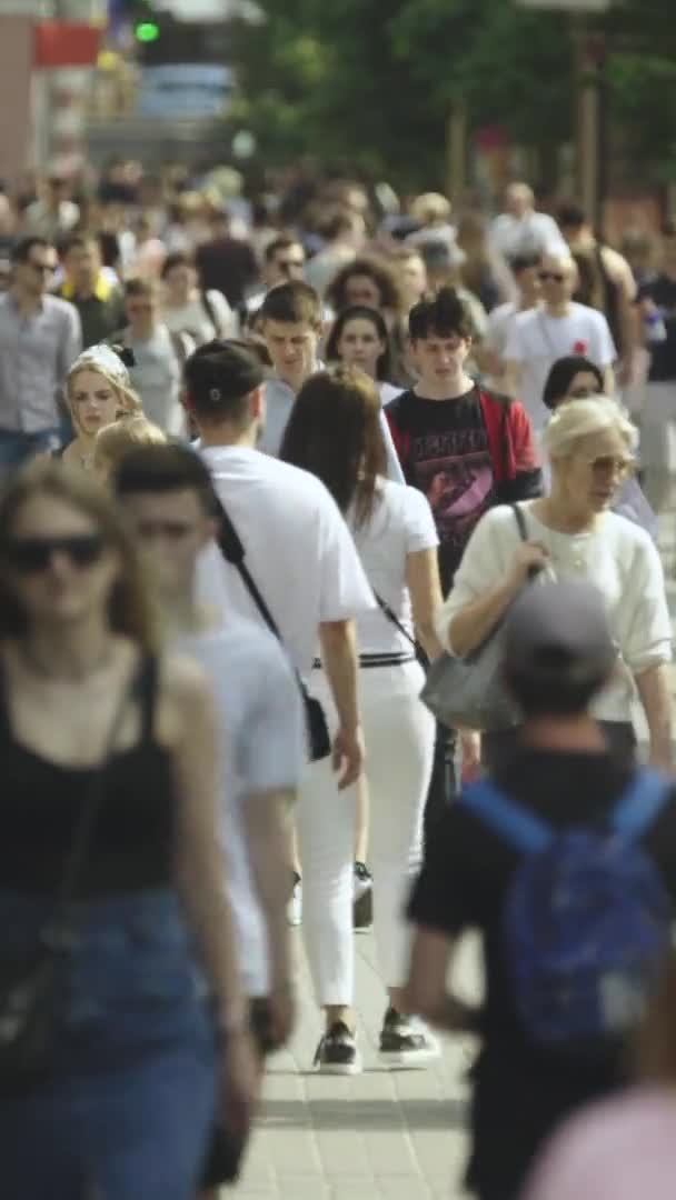 Vertikální video mnoha lidí procházejících se v davu podél městské ulice — Stock video