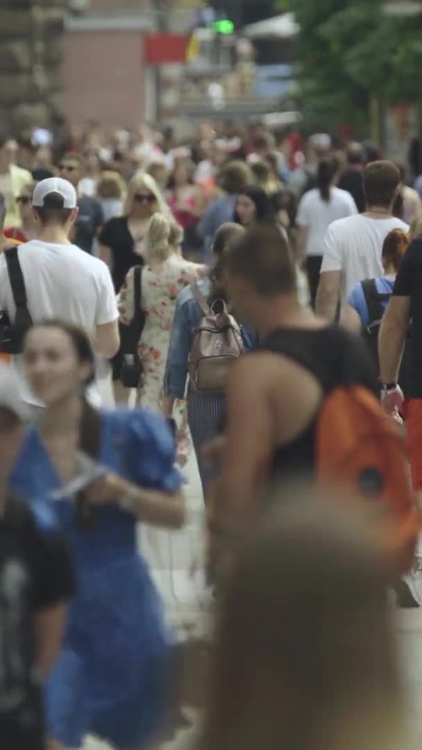 Video verticale di molte persone che camminano in una folla lungo una strada della città — Video Stock