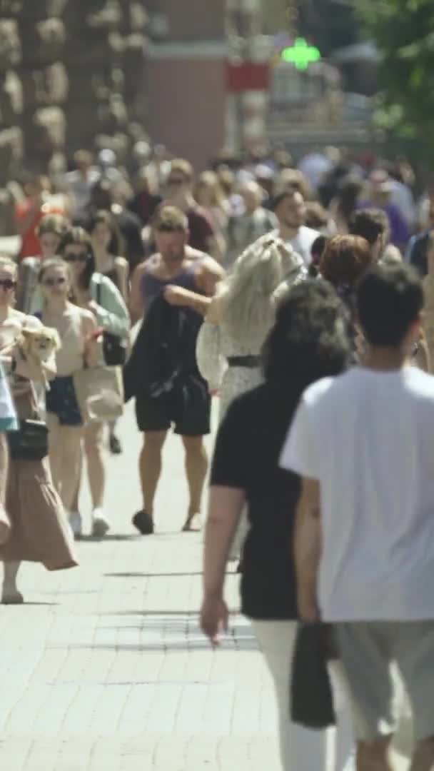 Video verticale di molte persone che camminano in una folla lungo una strada della città — Video Stock