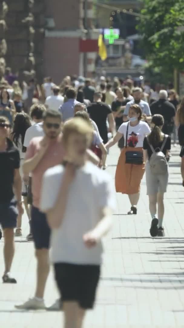 Vertical video of many people walking in a crowd along a city street — Stock Video