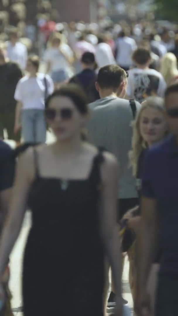 Vídeo vertical de muitas pessoas andando em uma multidão ao longo de uma rua da cidade — Vídeo de Stock