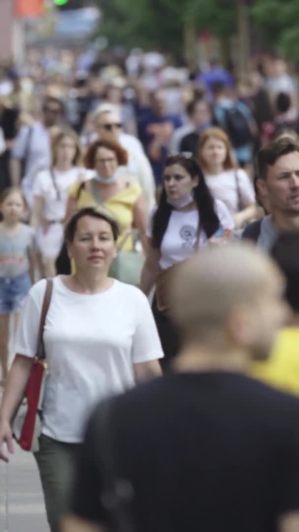 Pionowe wideo wielu ludzi spacerujących w tłumie wzdłuż ulicy miejskiej — Wideo stockowe