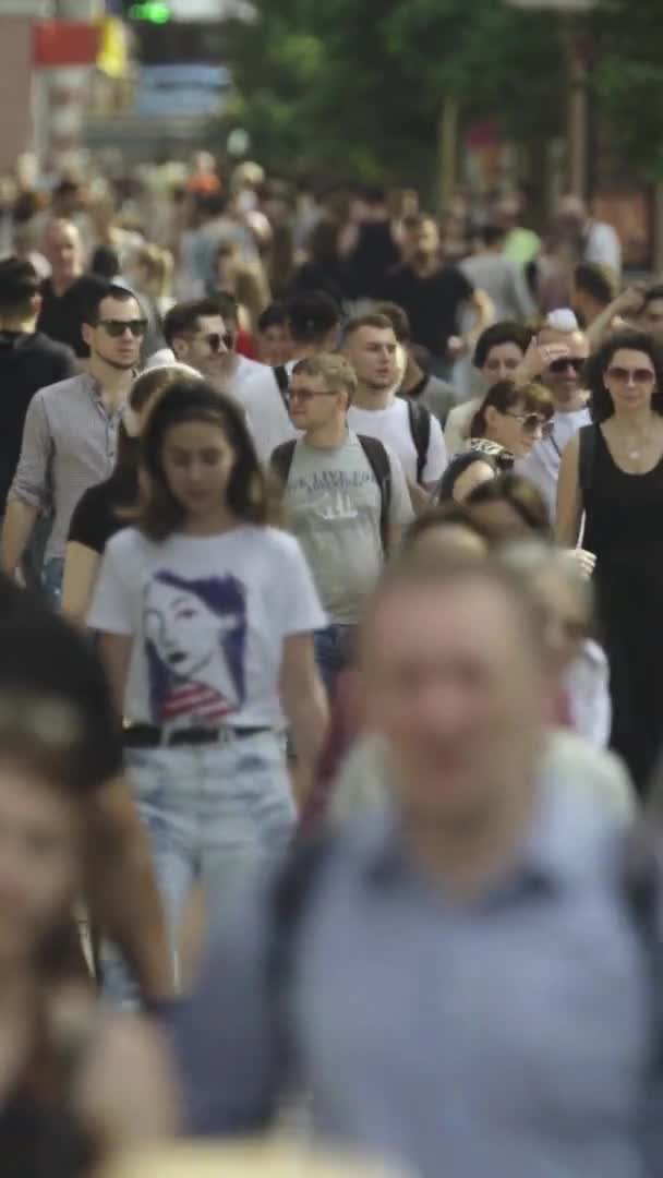 Video verticale di molte persone che camminano in una folla lungo una strada della città — Video Stock