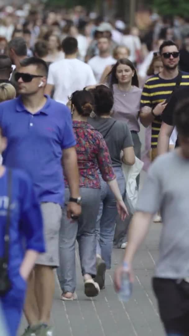 Pionowe wideo wielu ludzi spacerujących w tłumie wzdłuż ulicy miejskiej — Wideo stockowe
