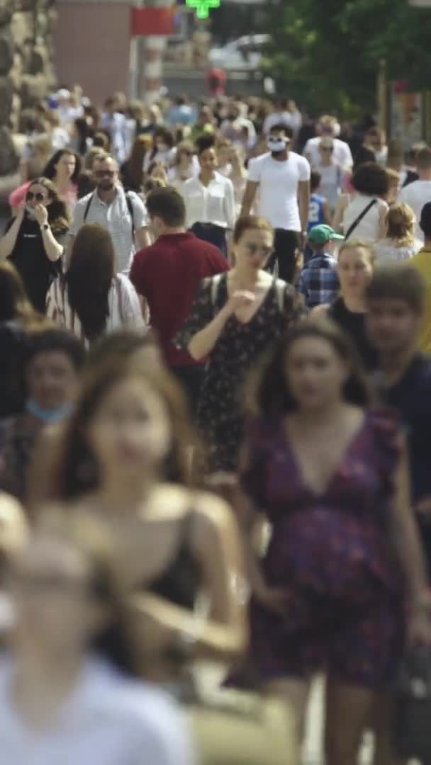 Vídeo vertical de muchas personas caminando en una multitud a lo largo de una calle de la ciudad — Vídeo de stock
