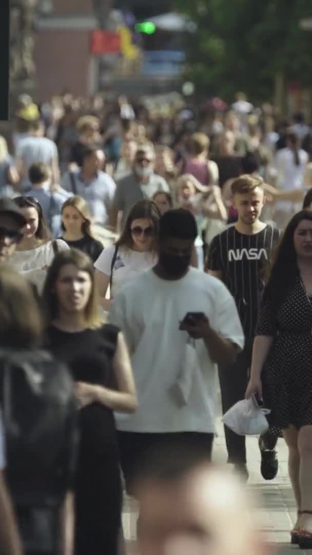 Vidéo verticale de nombreuses personnes marchant dans une foule le long d'une rue de la ville — Video