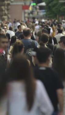 Gün boyunca kalabalık bir şehir sokağının dikey videosu