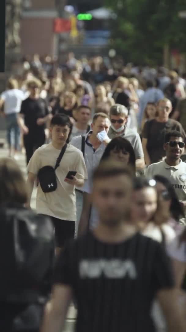 Vidéo verticale de nombreuses personnes marchant dans une foule le long d'une rue de la ville — Video