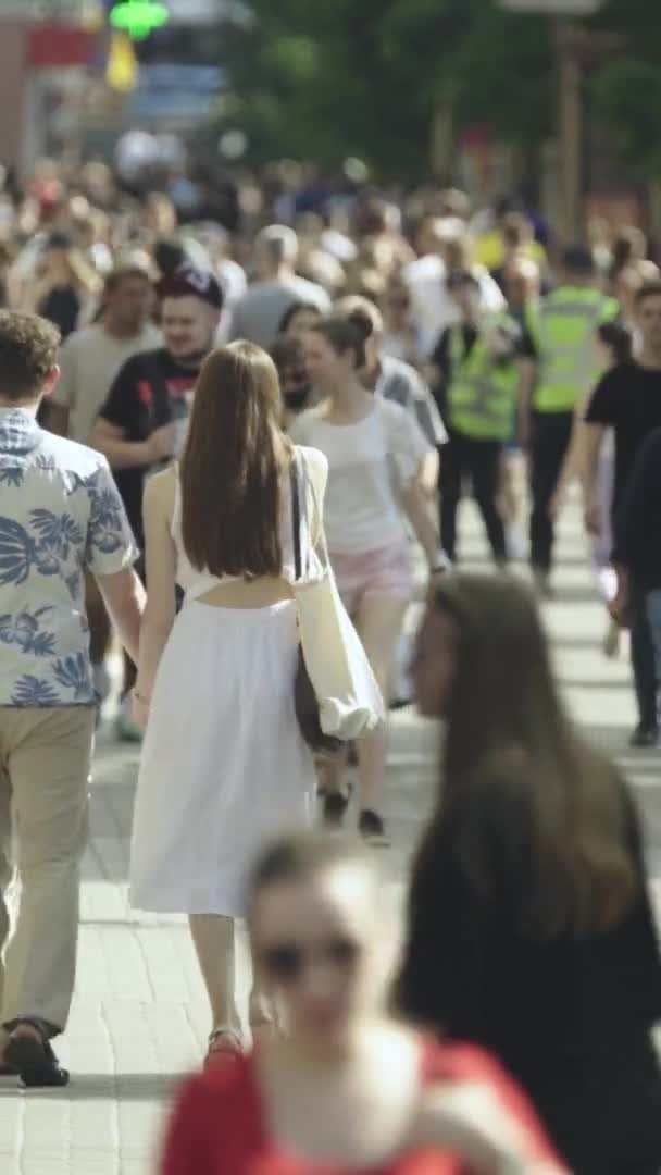 Vidéo verticale de nombreuses personnes marchant dans une foule le long d'une rue de la ville — Video