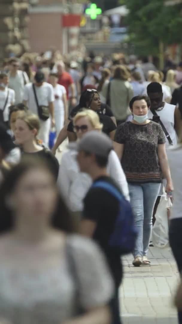 Video verticale di molte persone che camminano in una folla lungo una strada della città — Video Stock