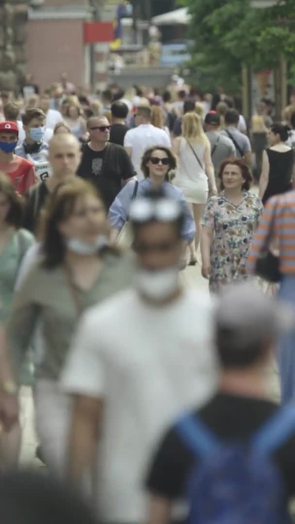 Vídeo vertical de muchas personas caminando en una multitud a lo largo de una calle de la ciudad — Vídeo de stock