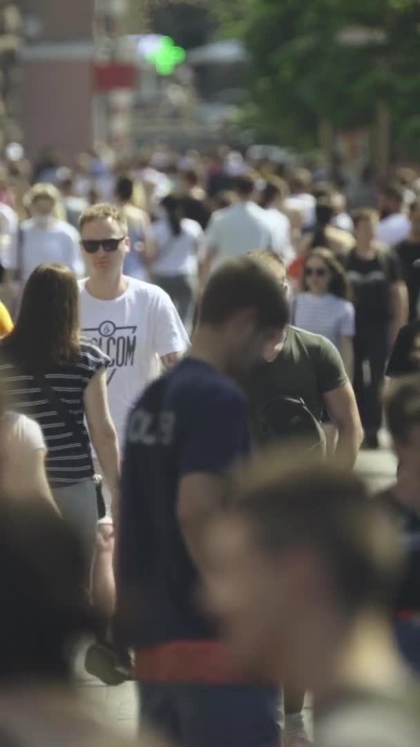 Şehir caddesi boyunca kalabalık içinde yürüyen bir sürü insanın dikey videosu. — Stok video