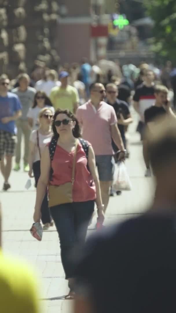 Κάθετη βίντεο από πολλούς ανθρώπους που περπατούν σε ένα πλήθος κατά μήκος ενός δρόμου της πόλης — Αρχείο Βίντεο