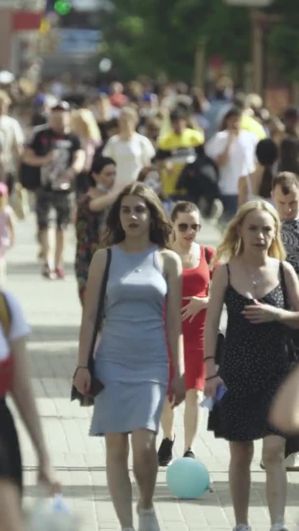 Vídeo vertical de muitas pessoas andando em uma multidão ao longo de uma rua da cidade — Vídeo de Stock