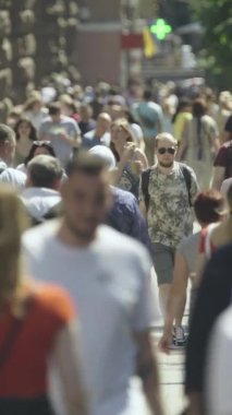 Gün boyunca kalabalık bir şehir sokağının dikey videosu