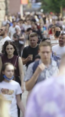 Gün boyunca kalabalık bir şehir sokağının dikey videosu