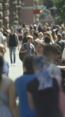 Gün boyunca kalabalık bir şehir sokağının dikey videosu