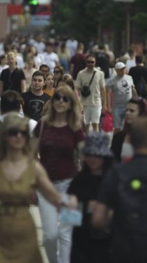 Gün boyunca kalabalık bir şehir sokağının dikey videosu