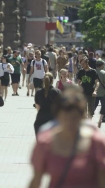 Gün boyunca kalabalık bir şehir sokağının dikey videosu