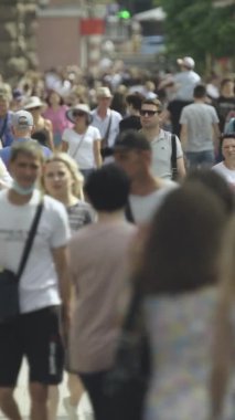 Gün boyunca kalabalık bir şehir sokağının dikey videosu