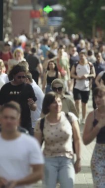 Gün boyunca kalabalık bir şehir sokağının dikey videosu