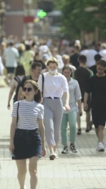 Gün boyunca kalabalık bir şehir sokağının dikey videosu