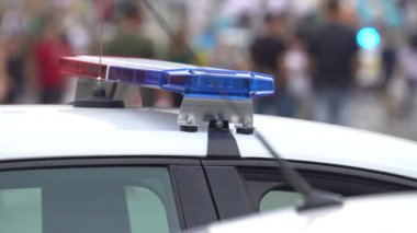 Polis arabasının çatısında teşhircilik yapan bir polis.