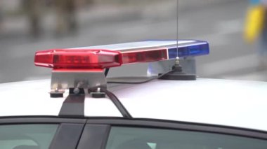 Polis arabasının çatısında teşhircilik yapan bir polis.