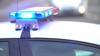 Polis arabasının çatısında teşhircilik yapan bir polis.