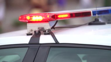 Polis arabasının çatısında teşhircilik yapan bir polis.