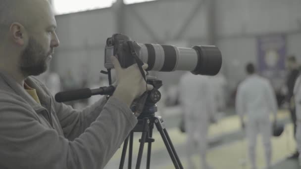 फोटोग्राफर कैमरामैन एक बाड़ लगाने प्रतियोगिता में काम करता है — स्टॉक वीडियो