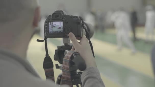 Fotograaf - cameraman werkt op een schermwedstrijd — Stockvideo