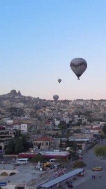 Türkiye 'nin Kapadokya üzerinde gökyüzünde uçan sıcak hava balonlarının dikey videosu.
