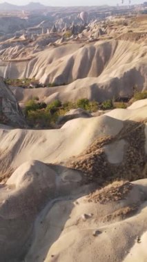 Türkiye 'nin Kapadokya üzerinde gökyüzünde uçan sıcak hava balonlarının dikey videosu.