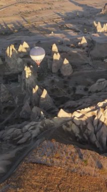 Türkiye 'nin Kapadokya üzerinde gökyüzünde uçan sıcak hava balonlarının dikey videosu.