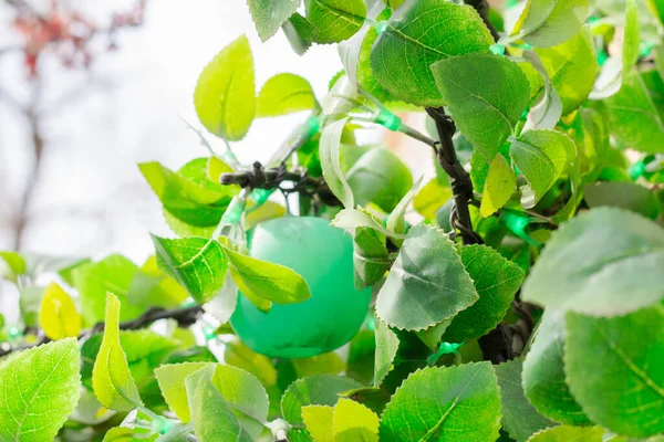 decorative tree on the street. Artificial leaves and fruits on the tree.